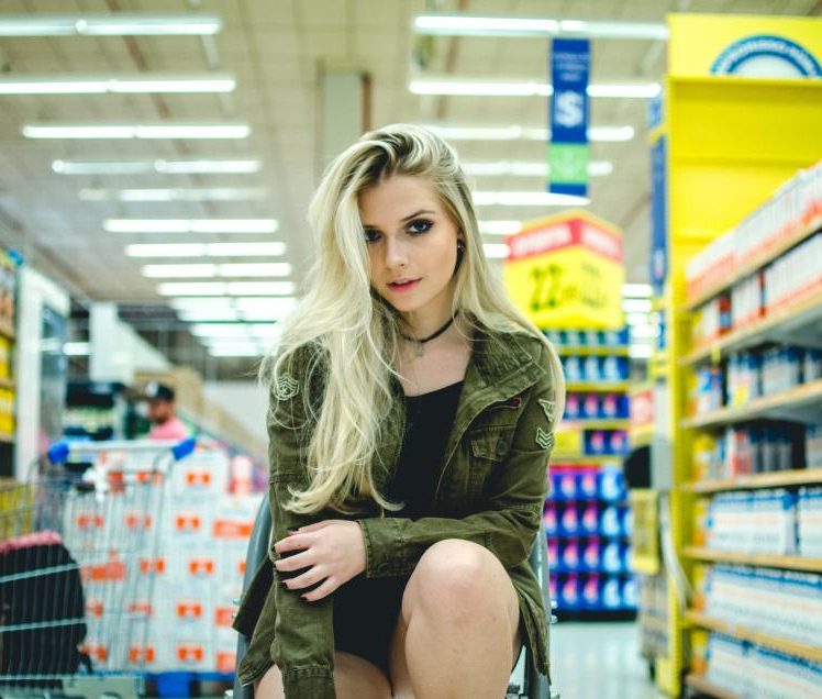 A shopper choosing between brands in a supermarket aisle