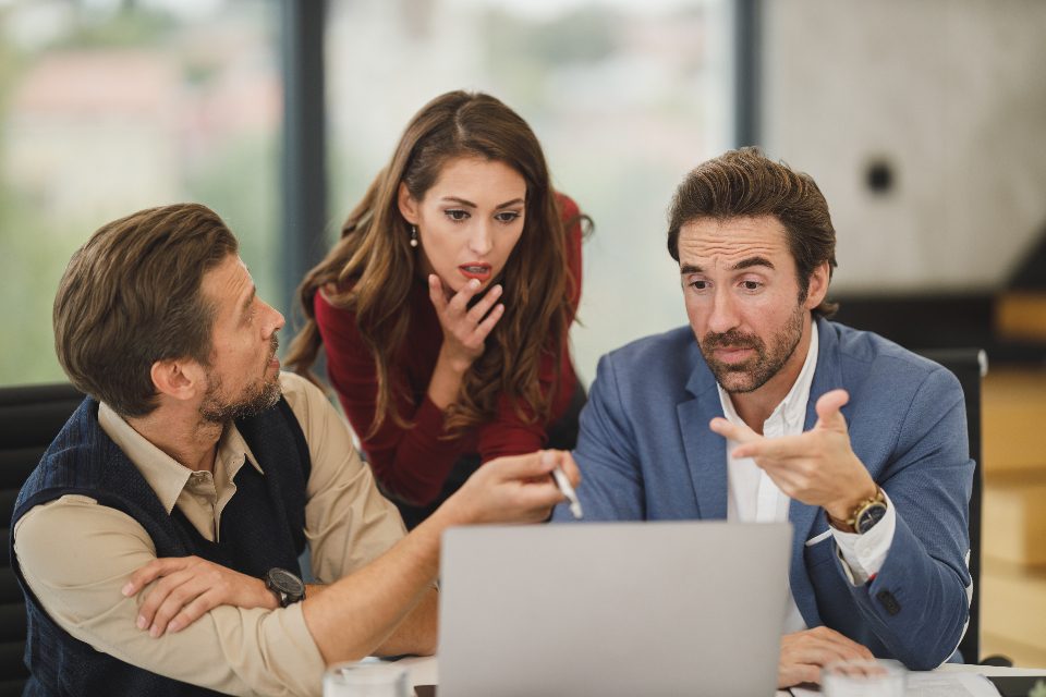 Colleagues discussing research results around a laptop