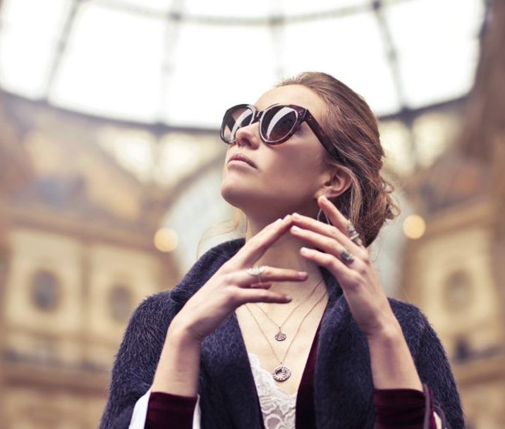 A woman with shopping bags under a glass-domed shopping arcade