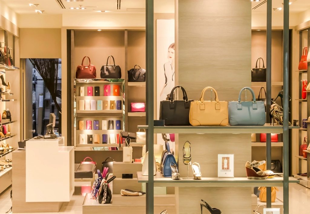 A boutique with leather handbags and shoes on wooden shelves